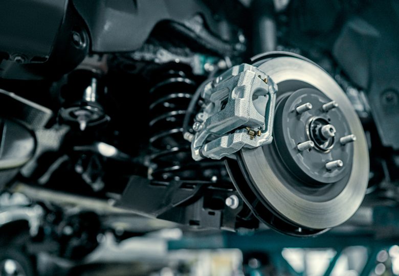 Disc brake of the vehicle for repair, in process of new tire replacement. Car brake repairing in garage.Suspension of car for maintenance brakes and shock absorber systems.Close up.